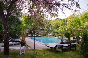 A swimming pool surrounded by lush greenery and seating areas. - Thante Hotel- Nyaung Oo (Nyaung-U)
