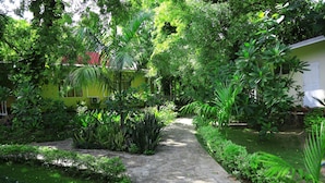 A garden pathway leading to a building with a yellow facade.