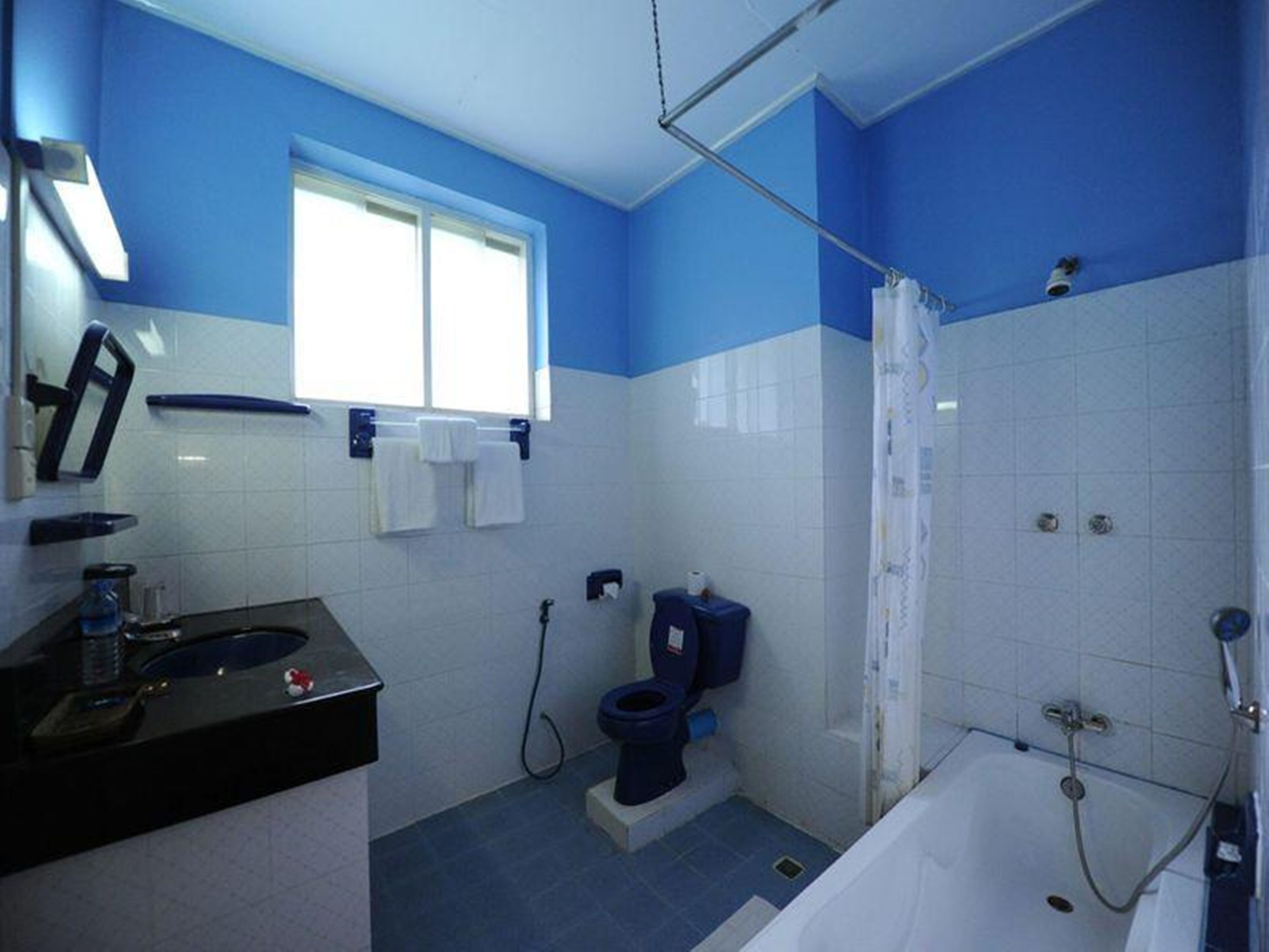Un baño con bañera, inodoro y lavamanos.