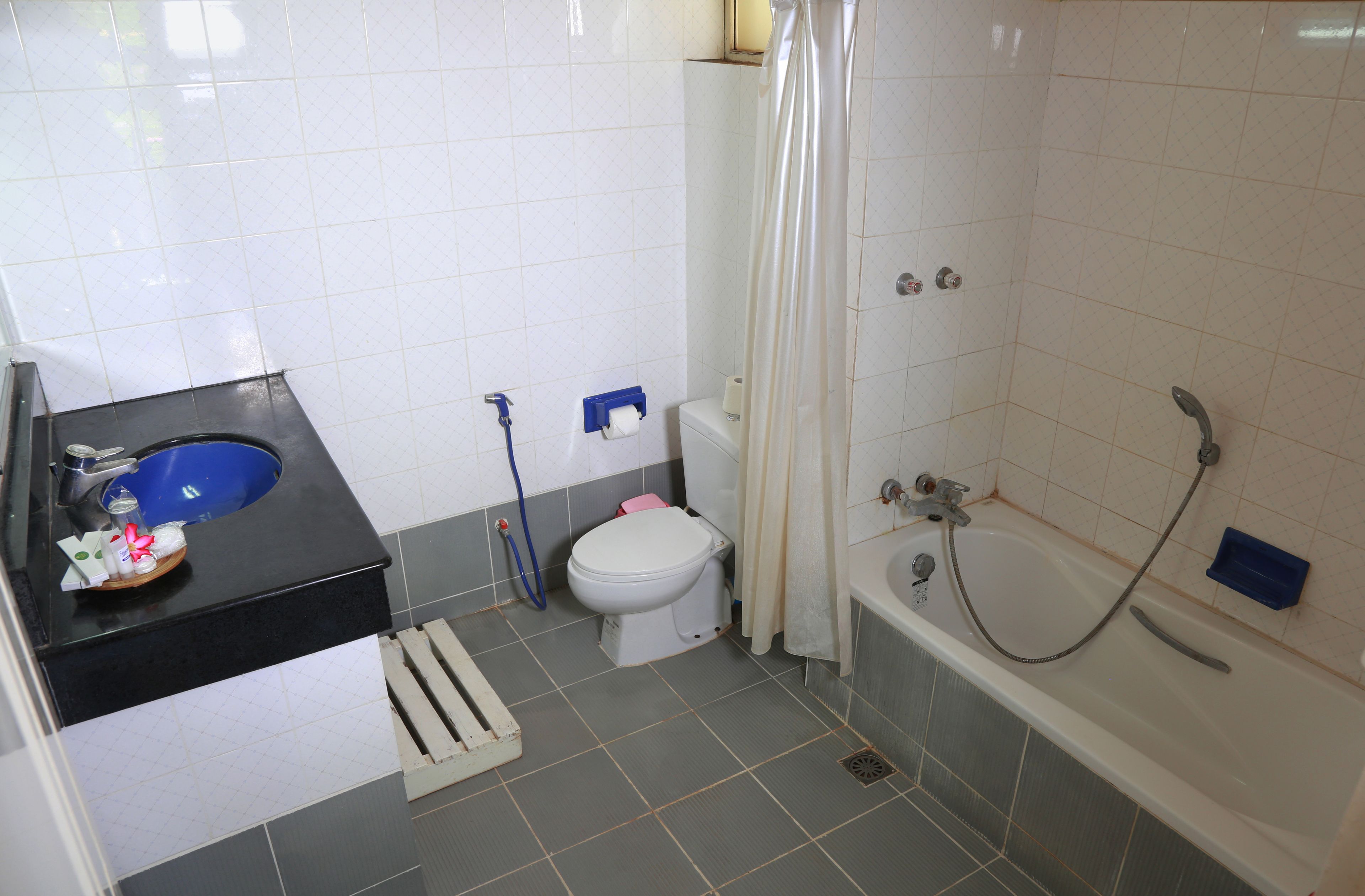 Een badkamer met een zwart wastafel, een wit toilet en een bad met douchegordijn.