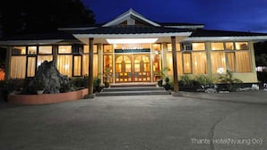 A hotel with a traditional architectural style, featuring a central entrance with a covered porch and large windows.