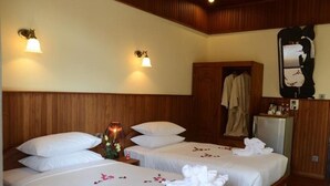 A hotel room with two beds, wooden headboards, and a mirror on the wall.
