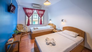 A hotel room with two beds, a TV, a chair, a bedside table, and a window with curtains. - Ostello Bello Nyaung Shwe (Nyaungshwe)