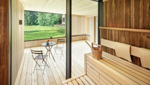 A wooden deck with a table and chairs, a wooden bench, and a wooden wall. - Alpenhotel Kitzbühel (Kitzbuhel)