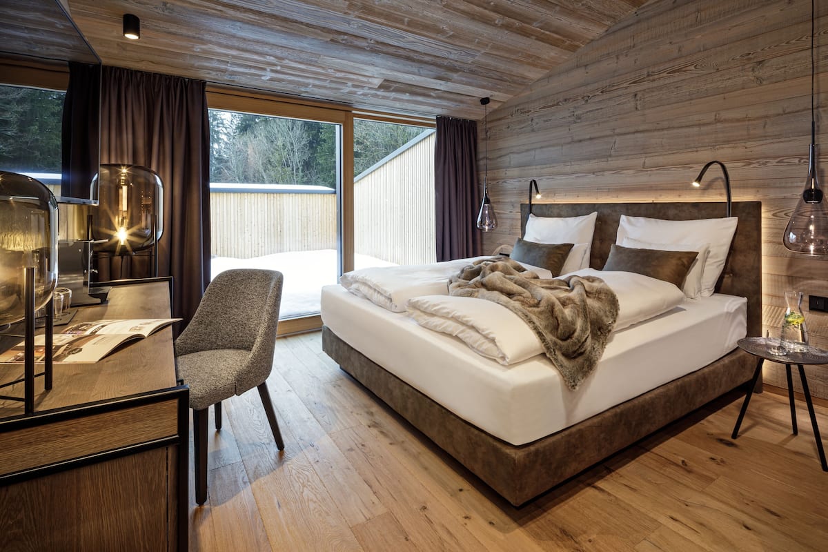 Une chambre avec un grand lit, un bureau et une chaise.