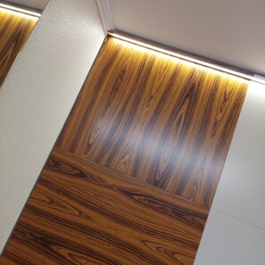 A corner of a room with a wooden panel wall and a white wall. - Amadora Palace Hotel (Amadora)