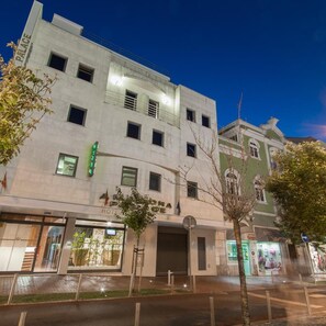 A hotel with a modern facade, multiple windows, and a green sign indicating a restaurant. - Amadora Palace Hotel (Amadora)
