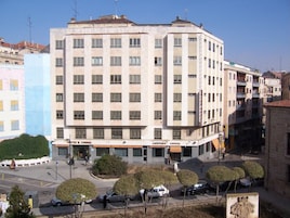 A multi-story hotel with a central courtyard, featuring a café and restaurant on the ground floor.