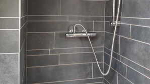 A shower with a handheld showerhead and a wall-mounted faucet. - Hotel Bellington (Amsterdam)