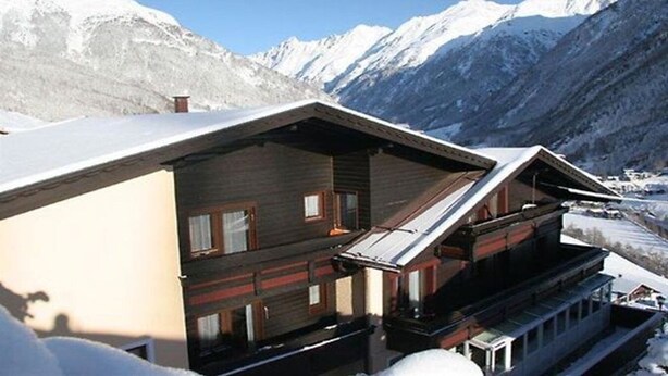 A chalet-style building with a sloped roof and wooden exterior, situated in a snowy mountainous area with clear skies. - Pension Stefanie (Soelden)