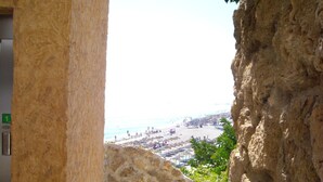 Un mur de pierre donnant sur une plage, avec une pancarte indiquant le numéro de chambre : 1.