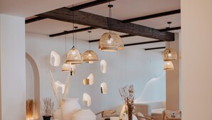 A modern interior with a wooden table, hanging wicker lamps, and potted plants. - Dunas de Doñana (Almonte)