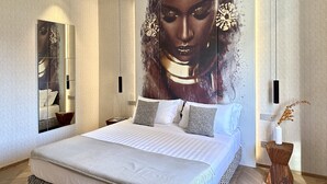 A modern bedroom with a large bed, a mirror, and a wall-mounted artwork. - Hotel Mealba Suite & Pool (Saronno)
