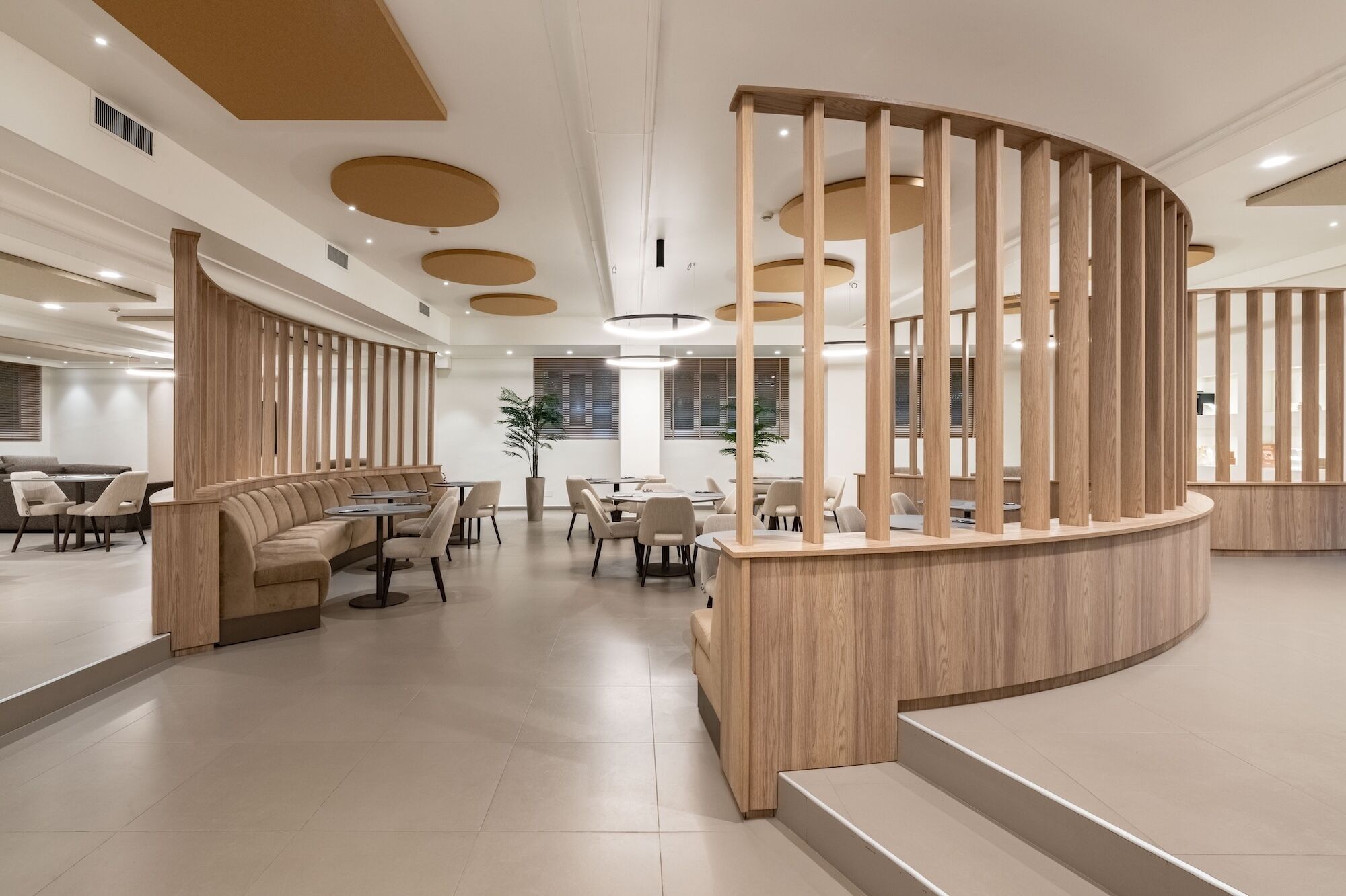 A modern interior with a curved reception desk, seating areas, and a clean, minimalist design.