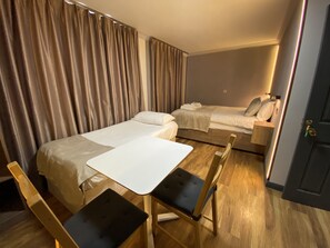 Familiekamer, meerdere bedden, uitzicht op tuin | Lakens van Egyptisch katoen, luxe beddengoed, een bureau