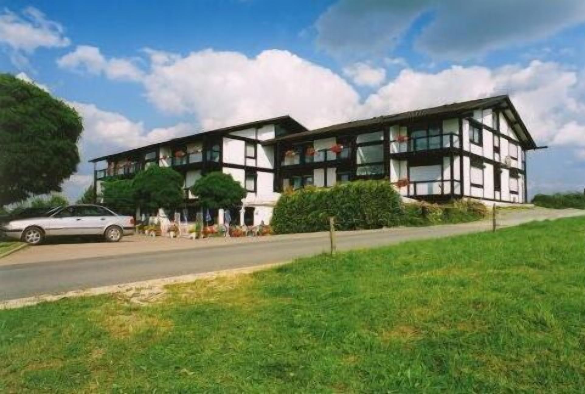 A two-story building with a traditional architectural style, featuring a mix of white and dark-colored panels.