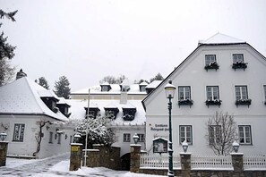 Un edificio cubierto de nieve con fachada blanca, numerosas ventanas y un estilo arquitectónico tradicional.