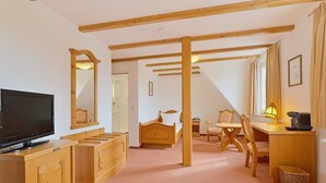 A room with a bed, a desk, a chair, a television, and a mirror. - Post, ZUR (Bonn)