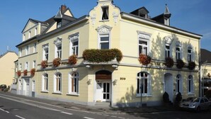 A yellow building with a classic architectural style, featuring a central entrance with a door and windows on the upper floors. - Post, ZUR (Bonn)