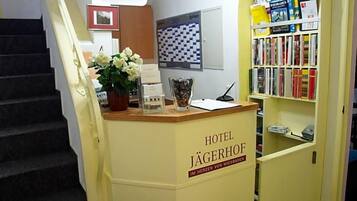 Ein Empfangstresen mit einem Schild, auf dem 'HOTEL JÄGERHOF IM HERZEN VON WIESBADEN' steht.