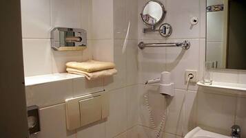 Ein Badezimmer mit Toilette, Waschbecken, Spiegel und Handtuchhalter.