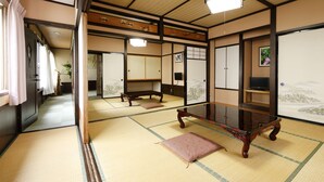 A traditional Japanese room with tatami flooring, a low wooden table, and sliding doors. - Ryoso Tsuyukusa (Takayama)