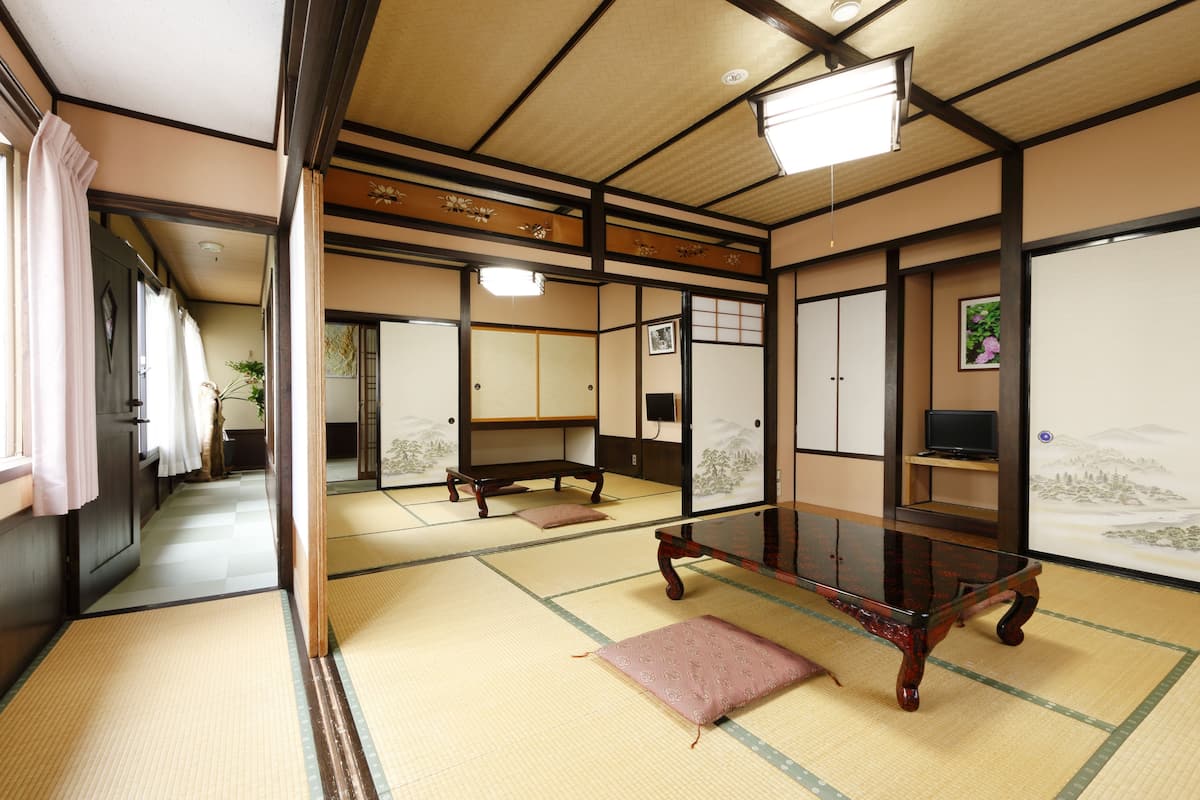 Une pièce de style japonais traditionnel, avec un sol recouvert de tatamis, une basse table en bois et des portes coulissantes.