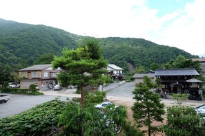 A residential area with houses, a paved road, and a mountain in the background. - Ryoso Tsuyukusa (Takayama)