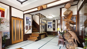 A traditional Japanese interior with tatami flooring, a wooden staircase, and a large wooden sculpture. - Ryoso Tsuyukusa (Takayama)