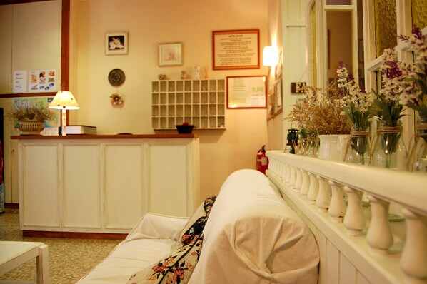 A hotel room with a bed, a nightstand, a lamp, a bulletin board, and a shelf with decorative items. - Maeva (Lloret de Mar)
