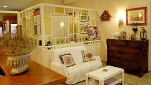 A living room with a white sofa, a wooden dresser, a white coffee table, and a decorative plant. - Maeva (Lloret de Mar)