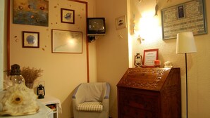 A room with a wooden dresser, a chair, and various wall decorations including framed pictures and a bulletin board. - Maeva (Lloret de Mar)