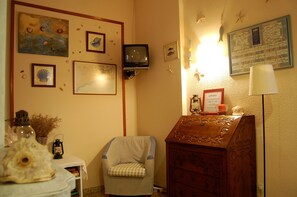 A room with a wooden dresser, a chair, and various wall decorations including framed pictures and a bulletin board. - Maeva (Lloret de Mar)