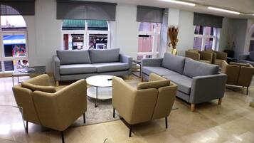 Un interior moderno con sofás y sillones dispuestos alrededor de una mesa de centro.