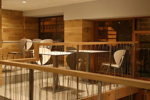 A modern interior with wooden panel walls, a glass railing, and contemporary furniture. - Hotel Picos de Europa (Santander)