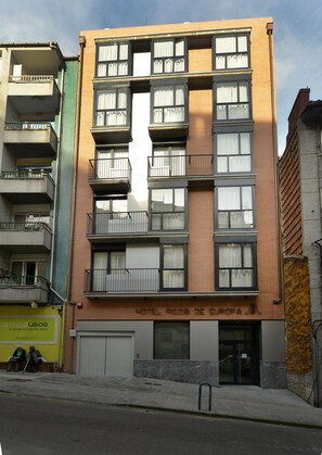 A multi-story hotel with balconies, a ground-level entrance, and a visible sign indicating it is a hotel. - Hotel Picos de Europa (Santander)