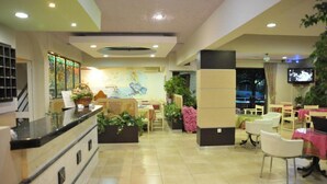 A hotel lobby with a reception desk, seating area, and a TV screen. - Anseli Hotel Apartments and Studios (Rhodes)