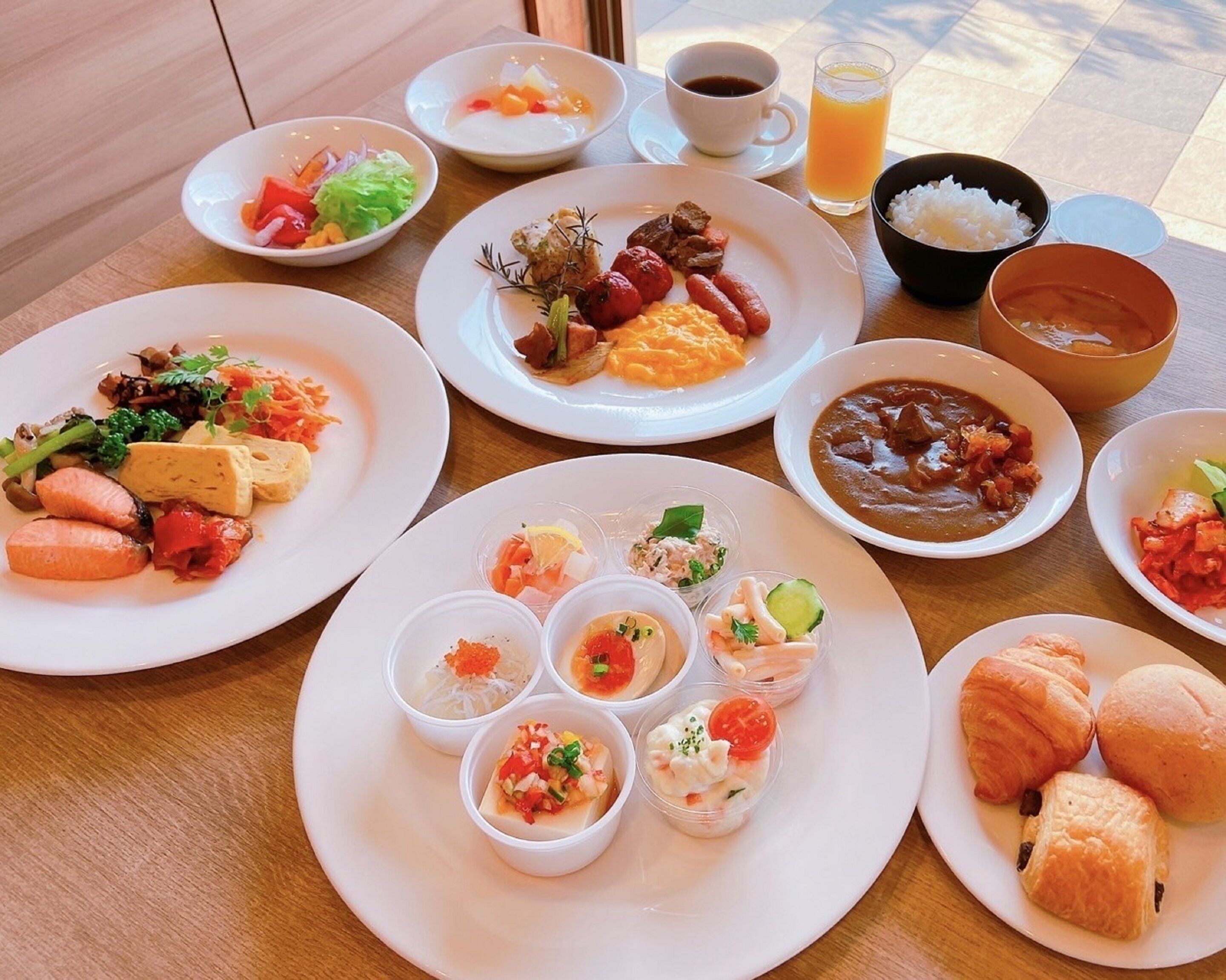 A table with various dishes including seafood, vegetables, and pastries, suggesting a meal setting.