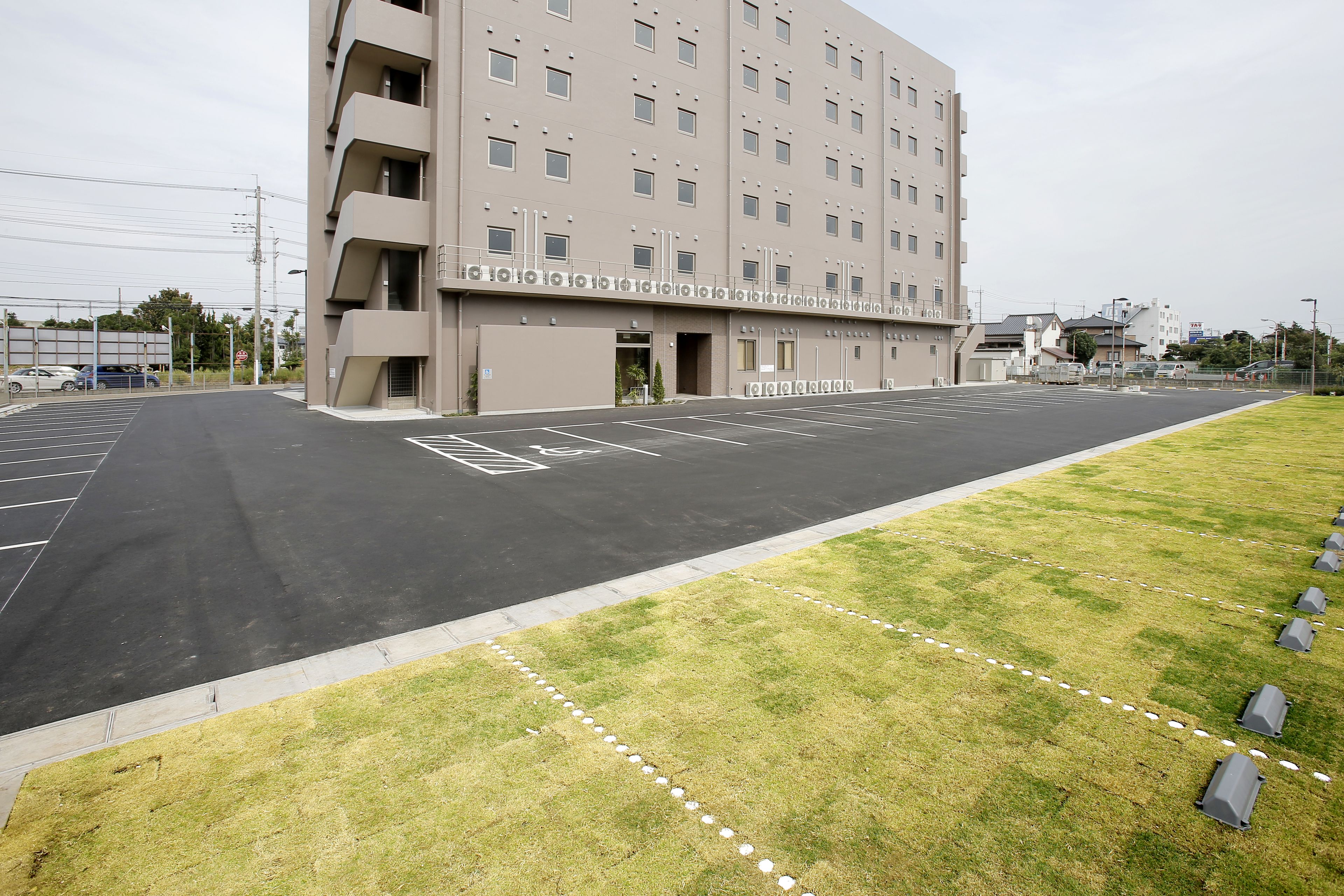 A multi-story hotel with a parking lot in front.