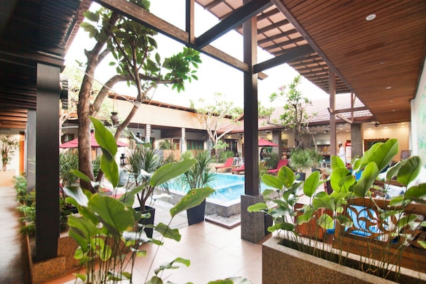 Una piscina al aire libre, sombrillas, sillones reclinables de piscina