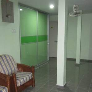 A room with a sliding door, a chair, and a small table with a cup. - Best Seven Motel (Langkawi)
