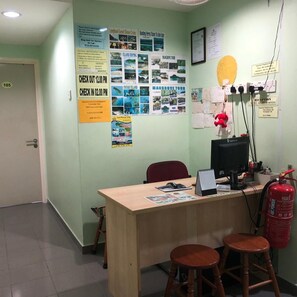 A reception desk with a computer, a fire extinguisher, and various informational posters on the wall. - Best Seven Motel (Langkawi)