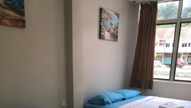 A hotel room with two beds, a painting on the wall, and a window with a view of the outside. - Best Seven Motel (Langkawi)
