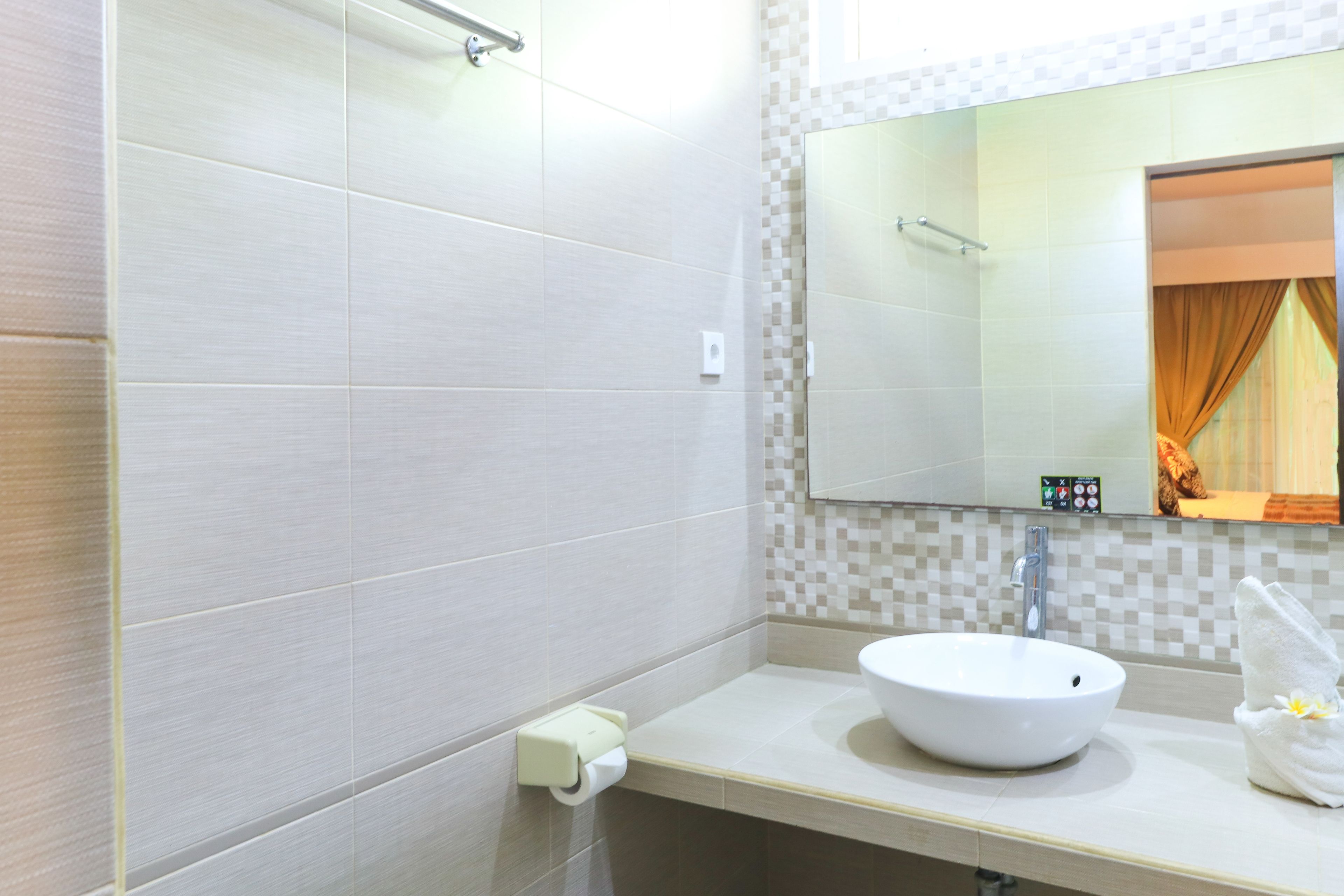 A bathroom with a white sink, a mirror, and a towel rack.