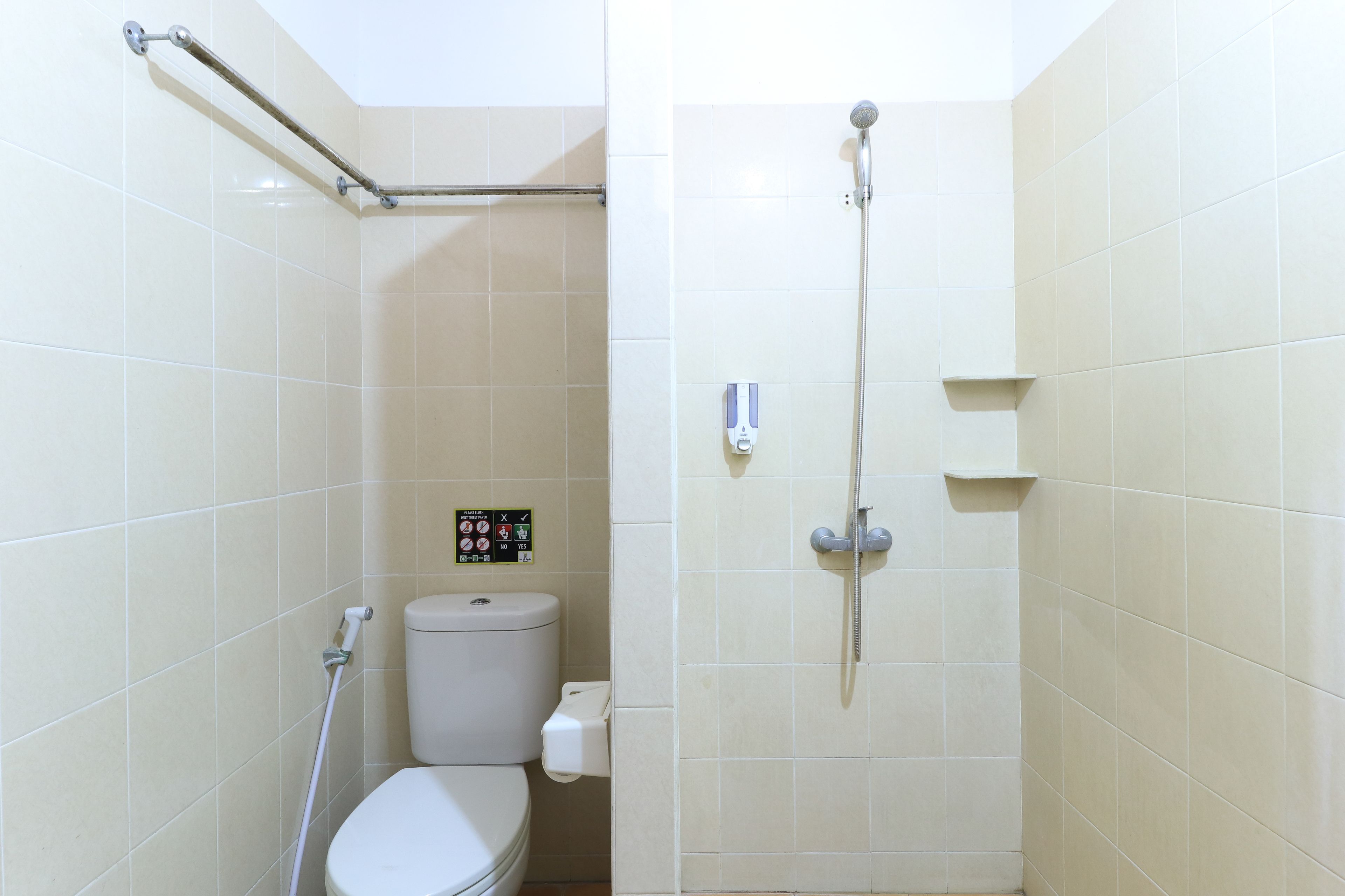 A small, clean bathroom with a toilet, a shower, and a hand dryer.