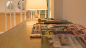 Una mesa de madera con revistas y una lámpara.