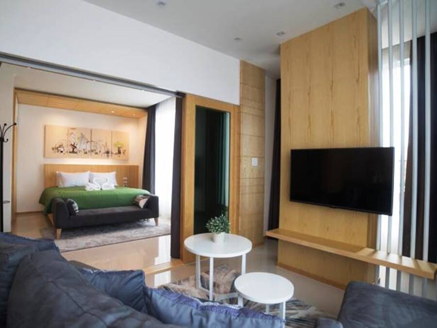 Una camera d'albergo moderna con un letto grande, una TV a schermo piatto, un divano e un tavolino.