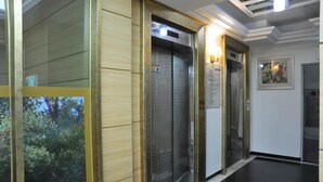 An elevator with a wooden panel design and a wall-mounted sign.
