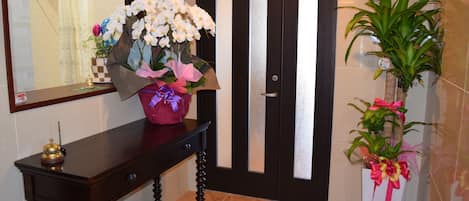 A wooden console table with a vase of flowers and a small figurine.