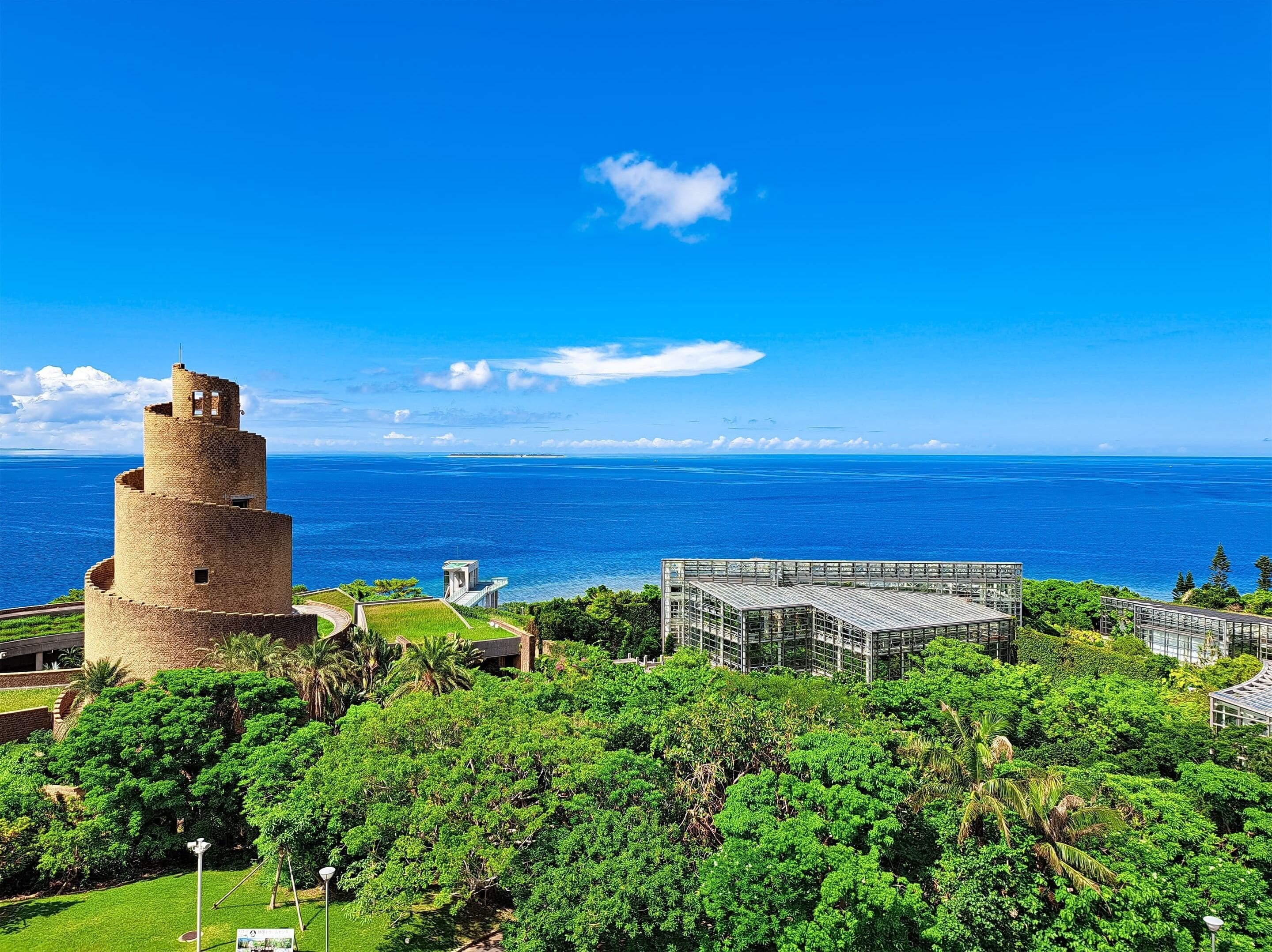 A historic tower and modern building with a view of the ocean.